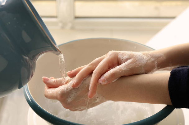 Mujer lavándose las manos en tazón
 - Foto, Imagen