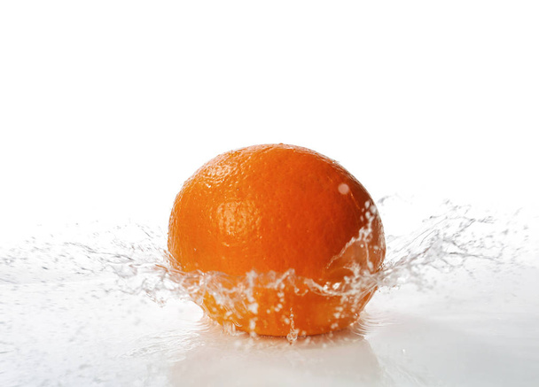 Naranja maduro con salpicadura de agua sobre fondo blanco
 - Foto, Imagen