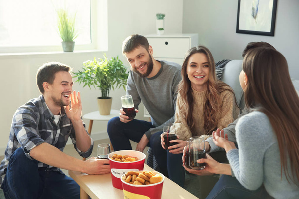 Gruppo di amici che mangiano pepite e bevono soda a casa
 - Foto, immagini