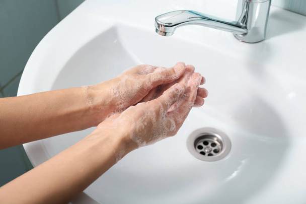 Frau wäscht sich die Hände im Waschbecken - Foto, Bild