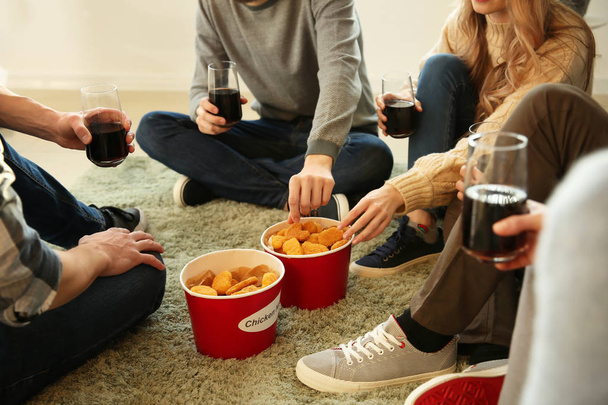 Ομάδα φίλων που τρώει ψήγματα στο σπίτι - Φωτογραφία, εικόνα