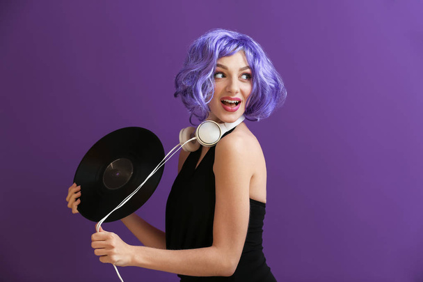 Mulher bonita com disco de vinil e fones de ouvido no fundo de cor
 - Foto, Imagem
