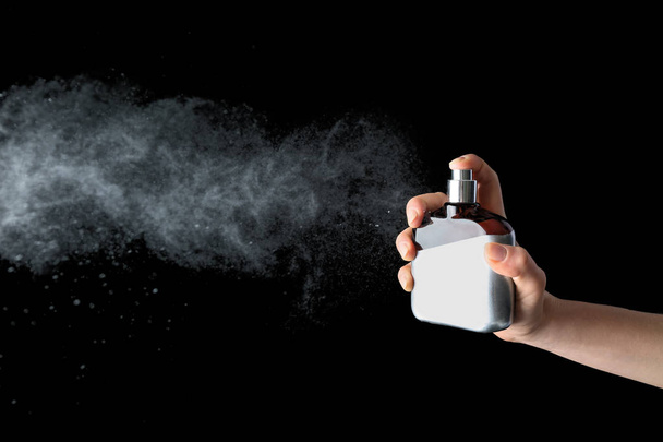 Female hand with bottle of perfume on dark background - Photo, Image