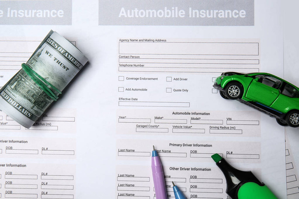 Automobile insurance forms with money and toy car - Фото, изображение