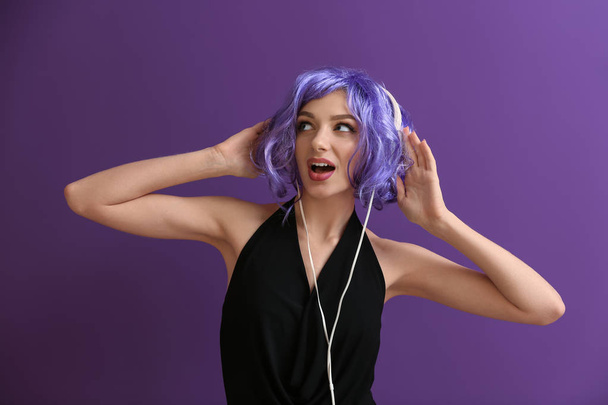 Gyönyörű fiatal nő hallgat zenét a színes háttér - Fotó, kép