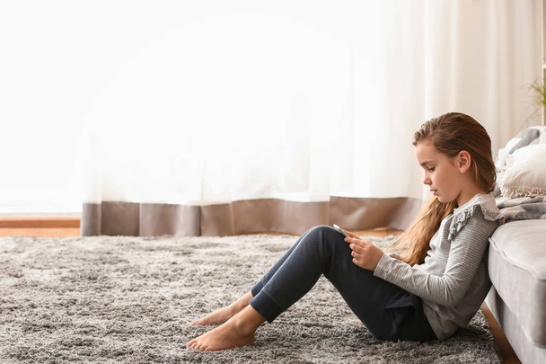 Schattig klein meisje met tablet pc kijken cartoons thuis - Foto, afbeelding