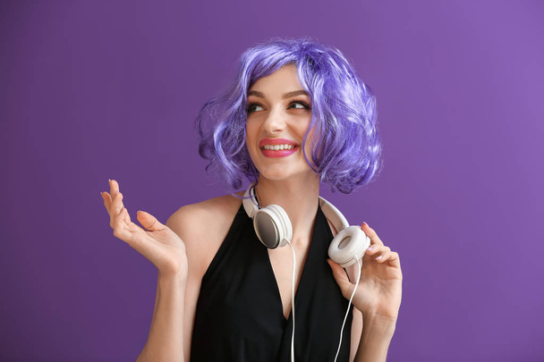 Beautiful young woman with headphones on color background - Valokuva, kuva