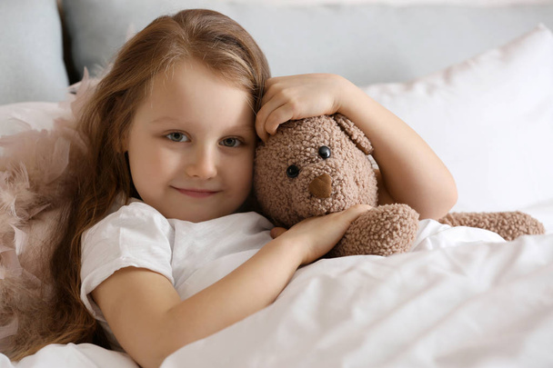 Söpö pieni tyttö lelu karhu sängyssä
 - Valokuva, kuva