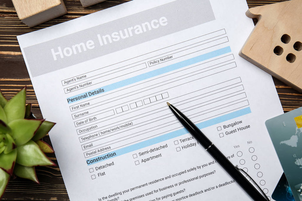 Home insurance form on wooden table - Foto, Imagen