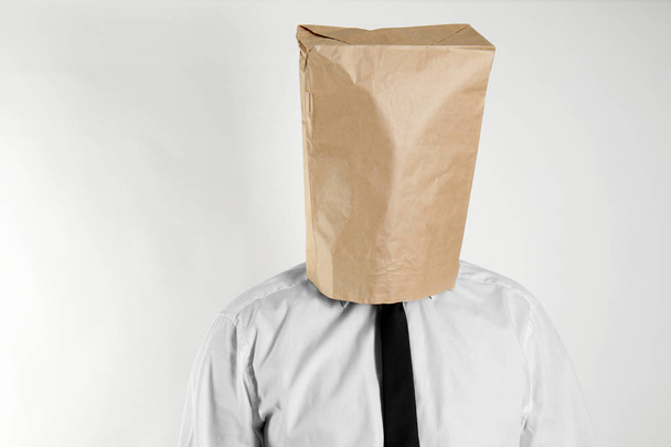 Homme d'affaires avec sac en papier sur la tête sur fond clair
 - Photo, image