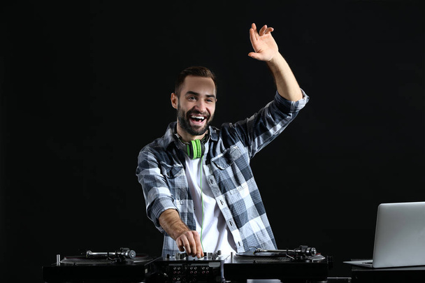 Мужчина DJ играет музыку на темном фоне
 - Фото, изображение