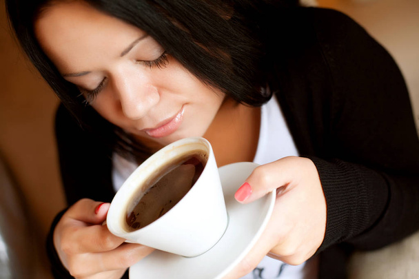 young woman sitting in a cafe drinking coffee - Фото, зображення