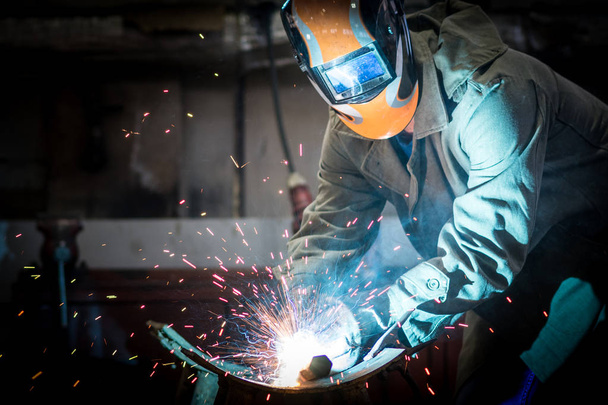 industrial worker at the factory welding steel construction - Fotoğraf, Görsel