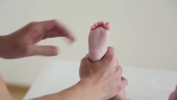 Mãe massagens seus bebês pernas com uma cara engraçada
 - Filmagem, Vídeo