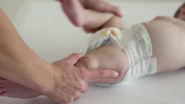 Mom massages his babys legs with a funny face - Séquence, vidéo