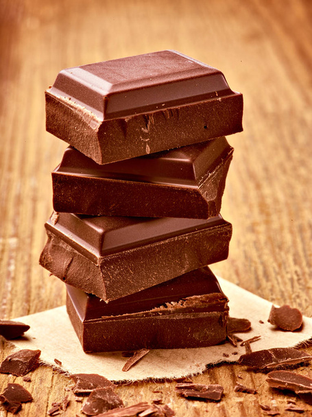 primer plano de piezas de chocolate sobre fondo de madera - Foto, imagen