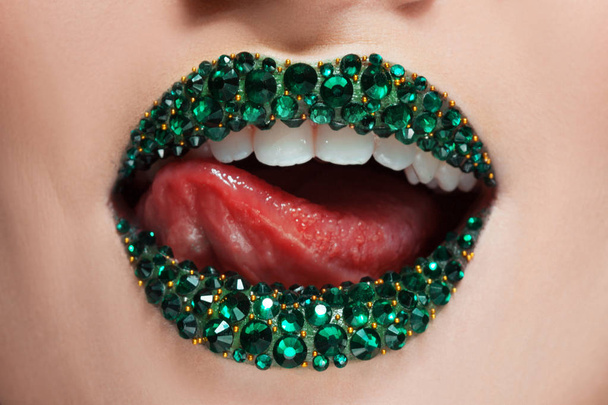 Green lips covered with rhinestones. Beautiful woman with Green lipstick on her lips - Photo, Image