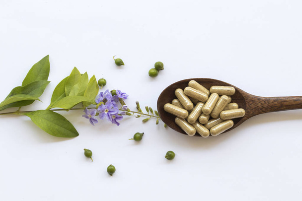 tablets capsules extract from herbal for woman eats with purple flowers decoration flat lay style on background white  - Photo, Image