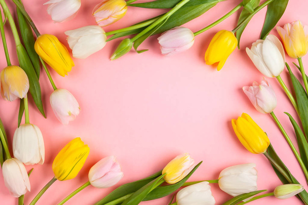 Beautiful white , pink and yellow tulips flowers on pink background. Spring flowers for Happy Easter card or for Mother's day holiday. Flat lay, top view. - 写真・画像