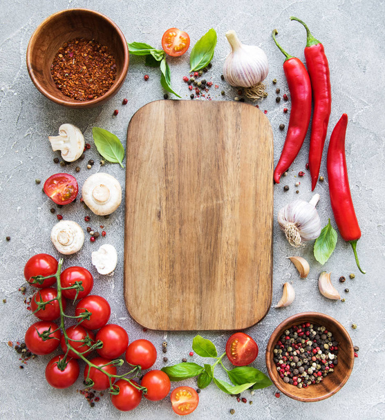 Empty board and fresh vegetables on a concrete background - Photo, Image