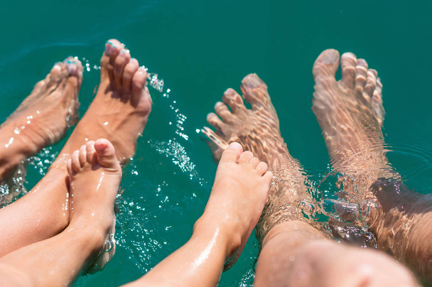 Happy family. Bare feets in the water of the sea boy, mother, father. Positive human emotions, feelings, joy. Funny cute child making vacations and enjoying summer. - Photo, image