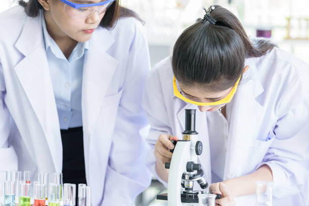 Asiático joven estudiante científico investigando y aprendiendo con científico senior han enseñando en un laboratorio
. - Foto, Imagen