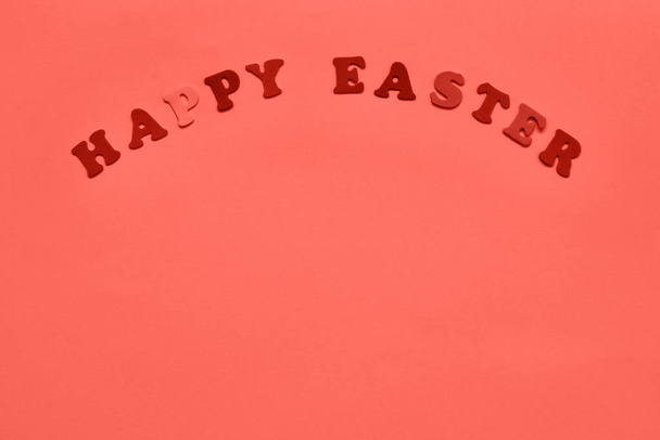 Easter background ispired by Living Coral. Letters forming words HAPPY EASTER in coral color. Copy space for your text. Flat lay of Easter celebration concept. Color of the Year 2019 - Zdjęcie, obraz