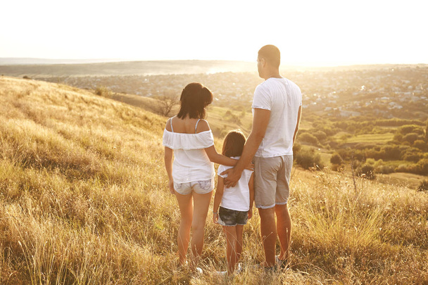 Happy family on nature in summer at sunset. - Фото, зображення