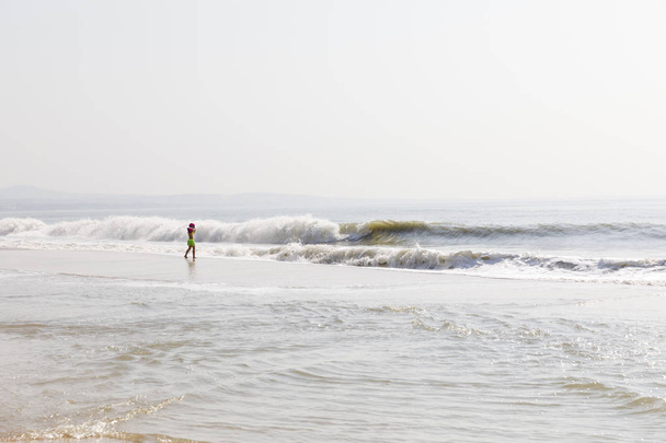 NAM TIEN, VIETNAM - 14 FÉVRIER 2018 : Un enfant observe les vagues de l'océan sur une plage de Nam Tien, au Vietnam
 - Photo, image