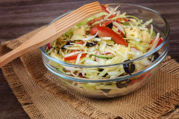 Fresh vegetables and vegetable salad in dishes on wooden background. - Foto, Imagen