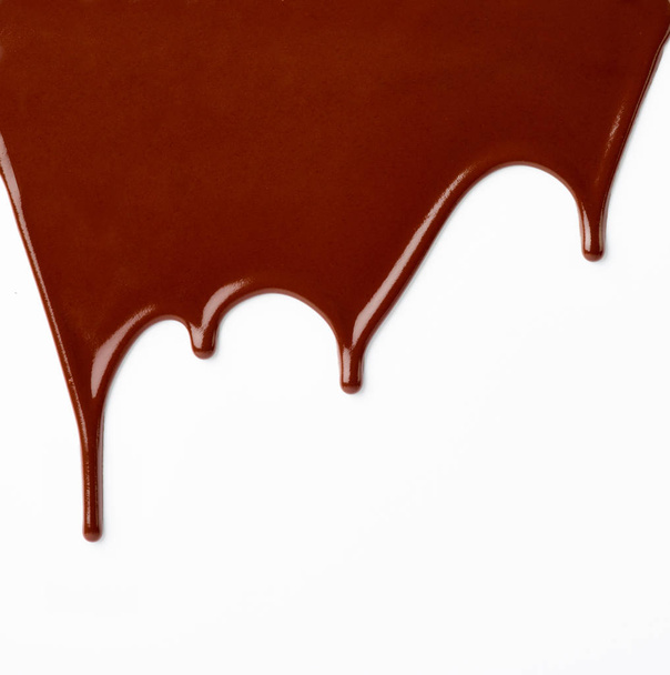 primo piano di sciroppo di cioccolato che perde su sfondo bianco - Foto, immagini