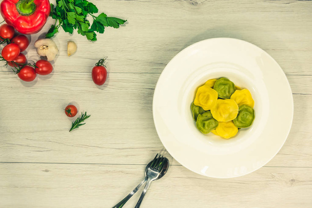Görünüm Cassic ravioli dolu fesleğen ve bir tabağa Beyaz ahşap bir masa vejetaryen yemek, beyaz peynir ile top. - Fotoğraf, Görsel