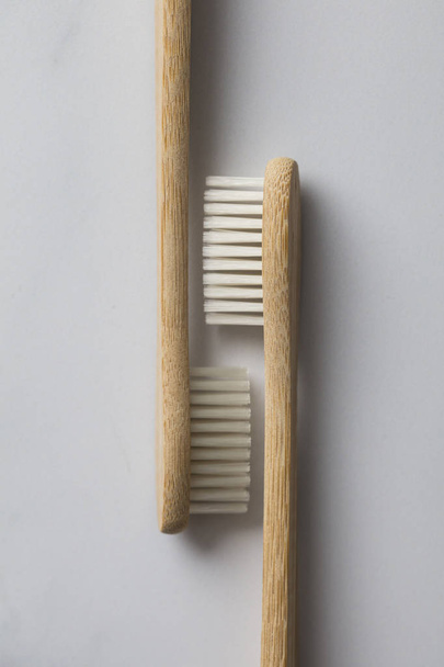 Wooden bamboo toothbrushs on a marble background - Foto, Bild