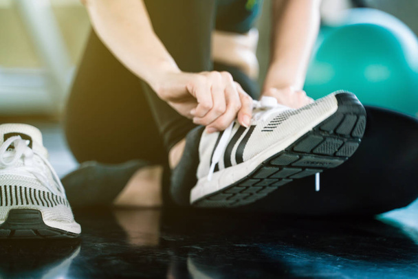 Close up women hand tying running shoe in gym, Sport concept - Фото, изображение