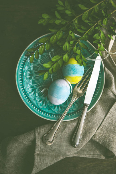 Tavolo primaverile allestito per Pasqua cena di vacanza con bosso e uova colorate su tavolo in legno con spazio copia
 - Foto, immagini