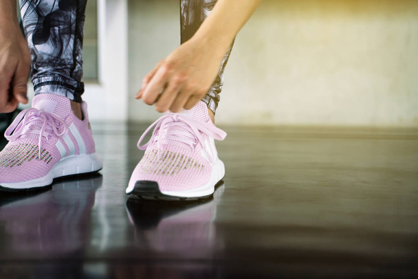 Close up women hand tying running shoe in gym, Sport concept - Foto, Imagen