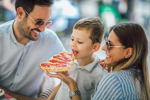 Muotokuva onnellinen perhe viettää aikaa pizzeriassa
 - Valokuva, kuva