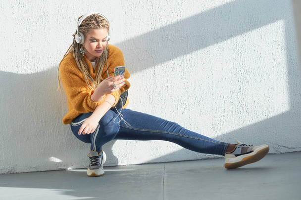 girl in headphones listening to music on mobile phone - Fotó, kép