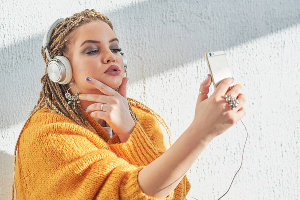 meisje in de koptelefoon te luisteren naar muziek op mobiele telefoon - Foto, afbeelding