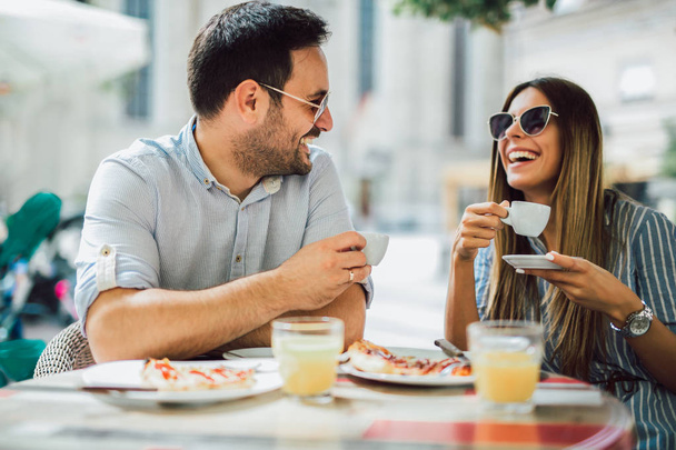 Couple eating pizza snack outdoors.They are sharing pizza and eating. - 写真・画像