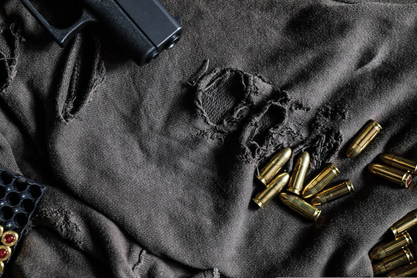 FMJ 9mm αυτόματο πιστόλι βαλλιστικό σε ύφασμα φόντο, έννοια της βίας - Φωτογραφία, εικόνα