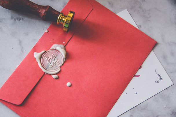 Papier roze envelop met zegellak stempel en uitnodiging kaart - Foto, afbeelding