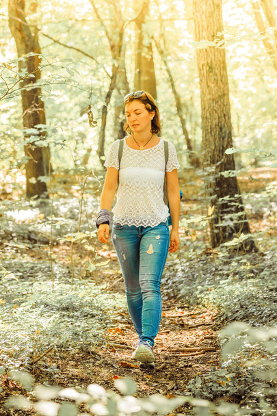 Caucasian young woman is walking in the wood, autumn - Photo, image