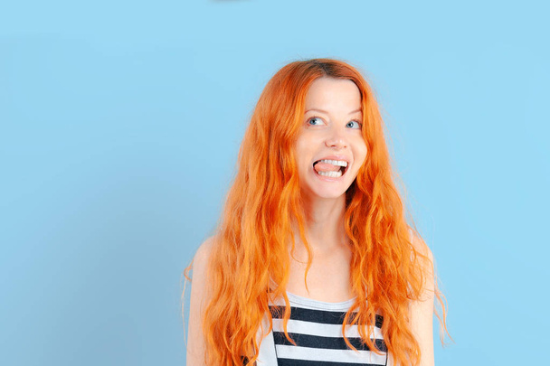 Redhead girl shows tongue and smiles. Positive and emotions - Foto, Imagen