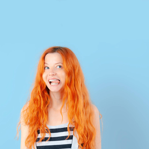 Redhead girl shows tongue and smiles. Positive and emotions - Φωτογραφία, εικόνα