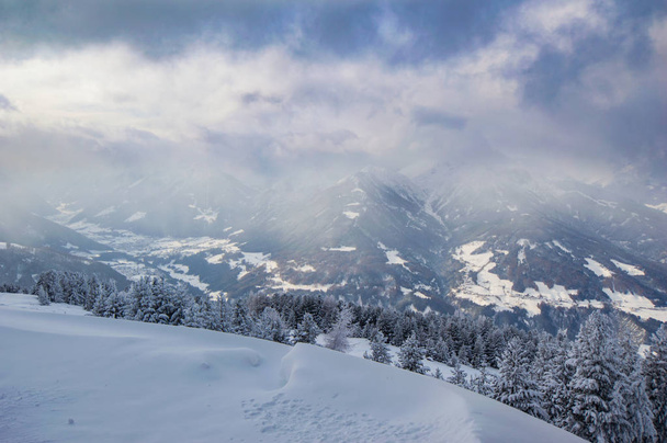 neve coberta colina com pinheiros foscos e rochas no fundo
 - Foto, Imagem