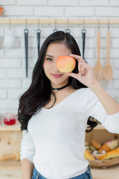 Beautiful young woman making a choice between a cake and apple - Foto, Bild