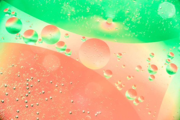oil bubbles in water close up on a red green background, colored abstract background - Photo, Image