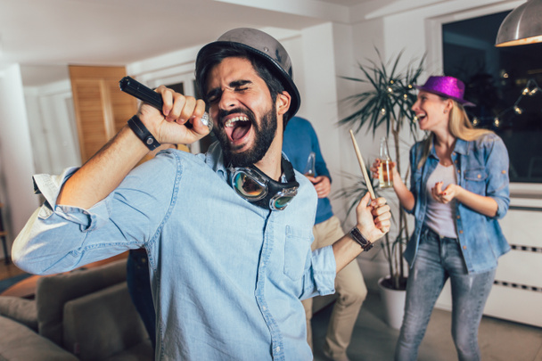 Gruppo di amici che giocano a karaoke a casa. Concetto di amicizia, intrattenimento domestico e persone - Foto, immagini
