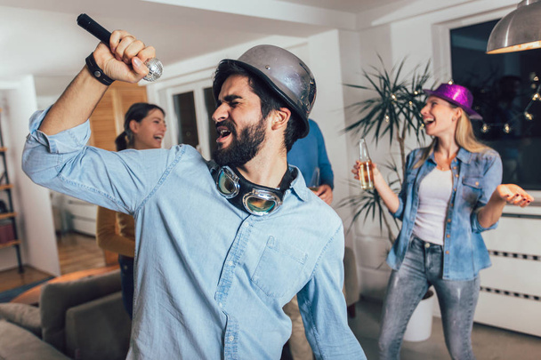 Gruppe von Freunden, die zu Hause Karaoke spielen. Konzept über Freundschaft, Unterhaltung zu Hause und Menschen - Foto, Bild